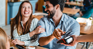 couple laughing and paying by scanning phone